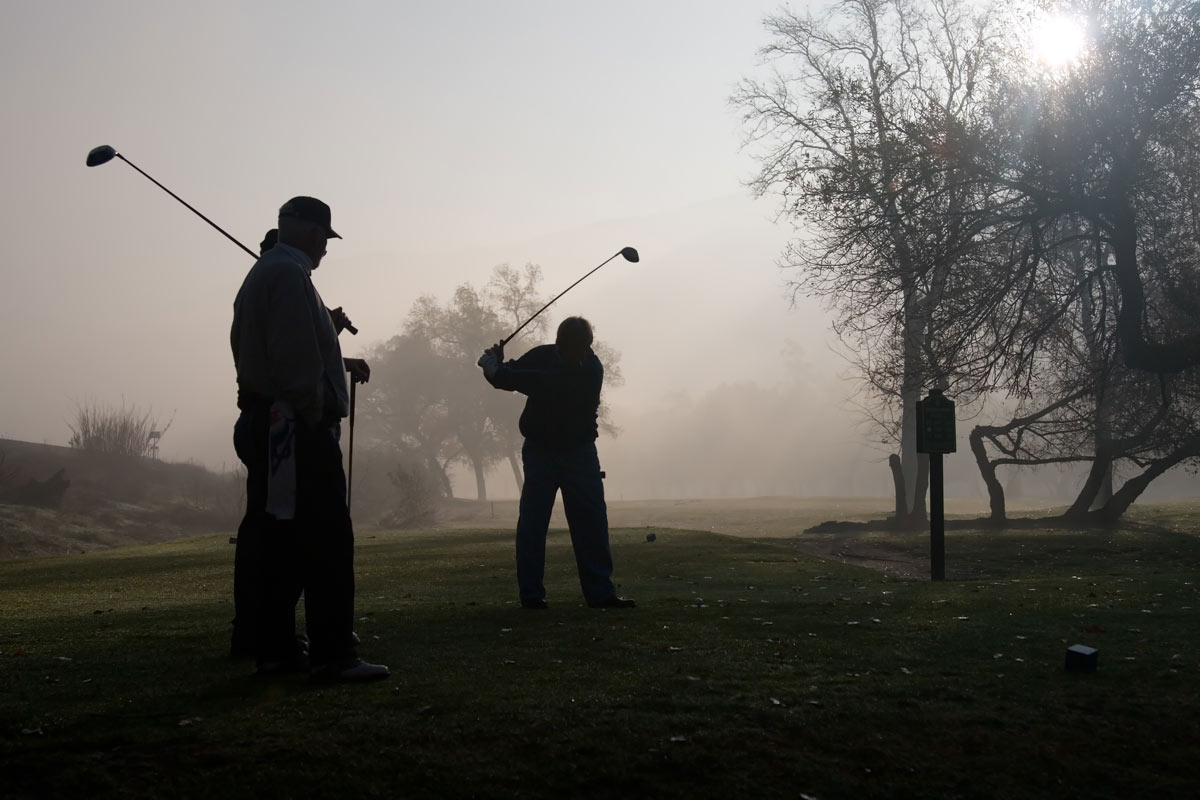 Golfers playing on a foggy Golf Course